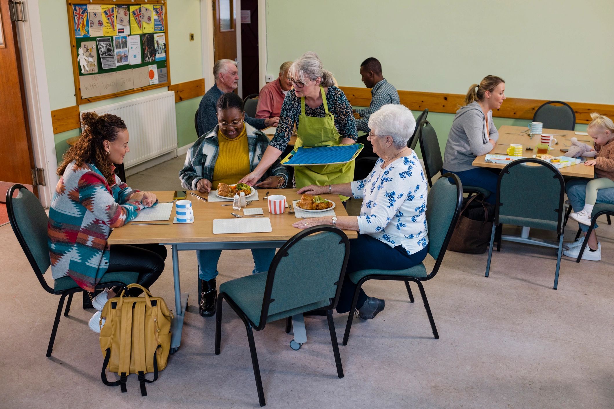 Volunteer serving meals in a community ministry setting