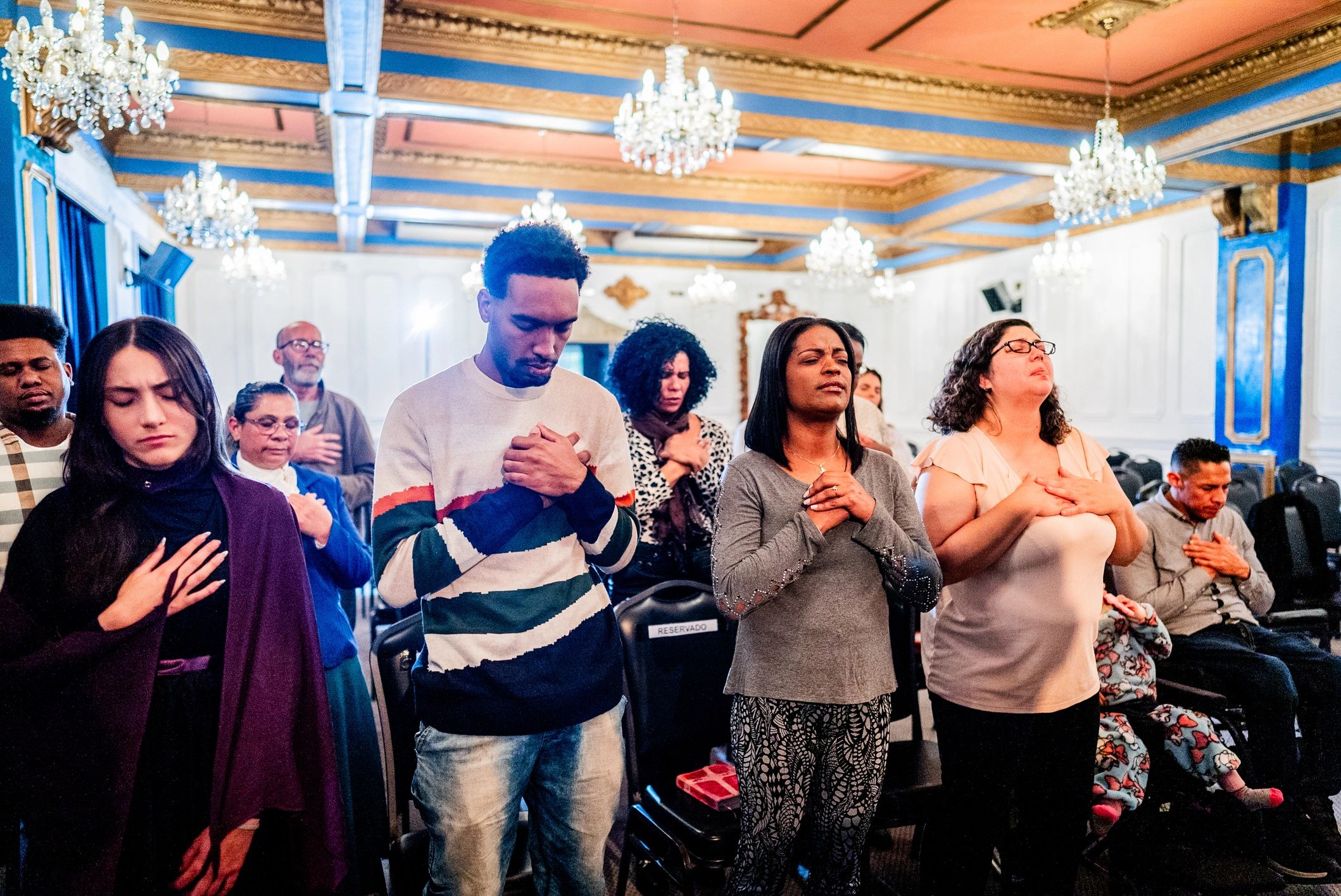 Diverse group of worshippers praying together in church